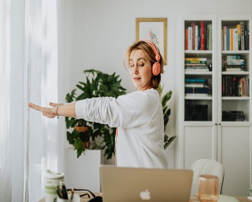 Person doing light stretching near an office desk naturally
